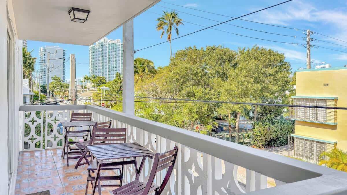 A balcony with a view of tall buildings and palm trees.