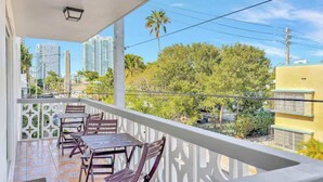 A balcony with a view of tall buildings and palm trees. - Newly Renovated 1BR Condo Near South Beach (Miami Beach)
