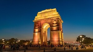 A large, illuminated archway with the inscription "India" at its top, surrounded by a crowd of people and street lamps. - Hotel S.R. Plaza (New Delhi)