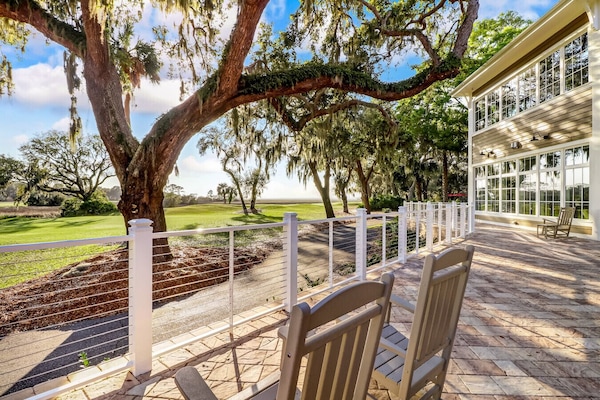 Shaded patio with rocking chairs and stunning oak views.