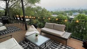 An outdoor patio with a sofa, chairs, a table, and string lights. - Uniquely Nashville, this Property has Amazing Views, A great Location to Unwind (Nashville)