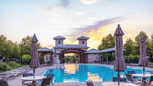 A pool area with lounge chairs and umbrellas, a bridge, and a building with a tower-like structure. - Pet Friendly, Pool, Shops, Downtown, Bourbon, Golf Local Dining, Fully Loaded (Prospect)