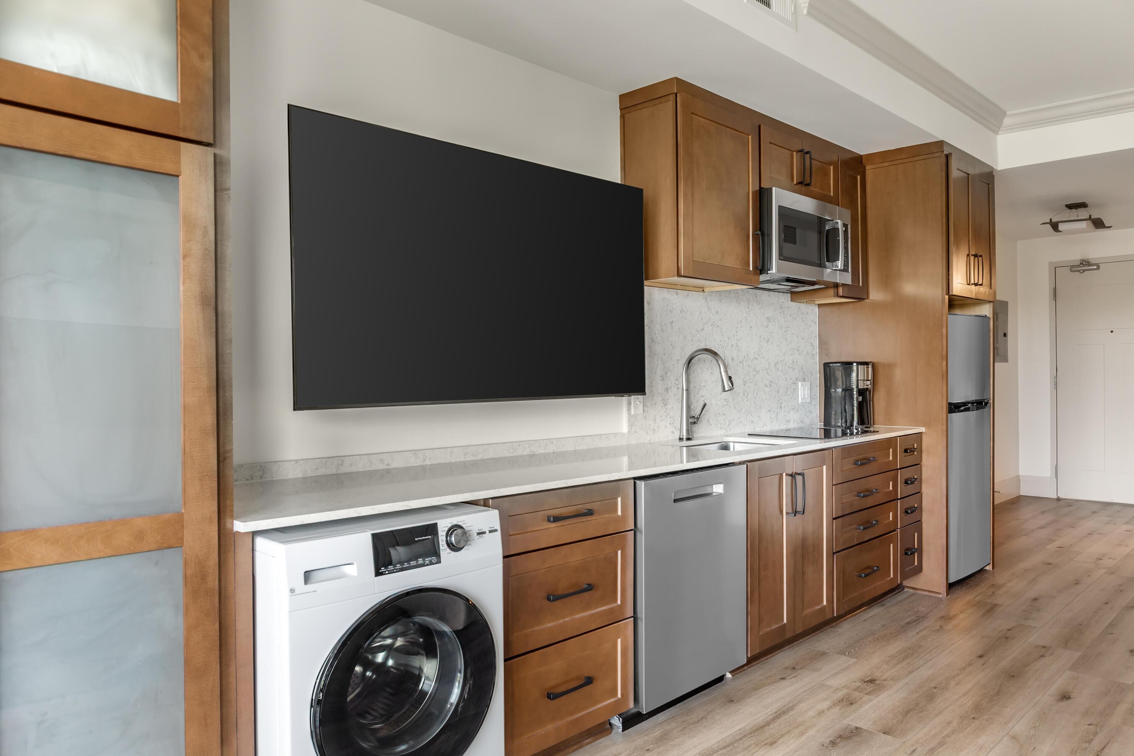 Une cuisine moderne avec des meubles en bois, des appareils en acier inoxydable et un four à micro-ondes encastré.