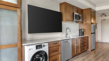Une cuisine moderne avec des meubles en bois, des appareils en acier inoxydable et un four à micro-ondes encastré.