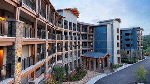 A multi-story hotel with balconies, stone pillars, and a covered entrance.
