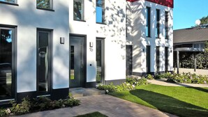 A modern building with a white facade, black-framed windows, and a red accent on the upper right. - Appartement in Strausberg mit Fruehstueck Inklusive (Strausberg)