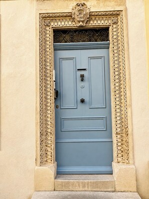 Uma porta azul com entalhes elaborados e moldura decorativa.