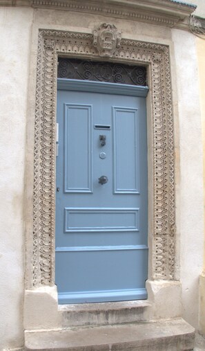 Traditional entrance with ornate metalwork and a decorative keystone.