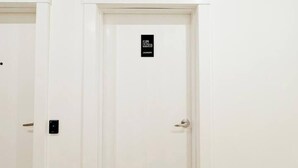 A hotel room with two white doors, one of which has a 'Laundry' sign. - The Charlotte • King Bed • Downtown Woodstock (Woodstock)