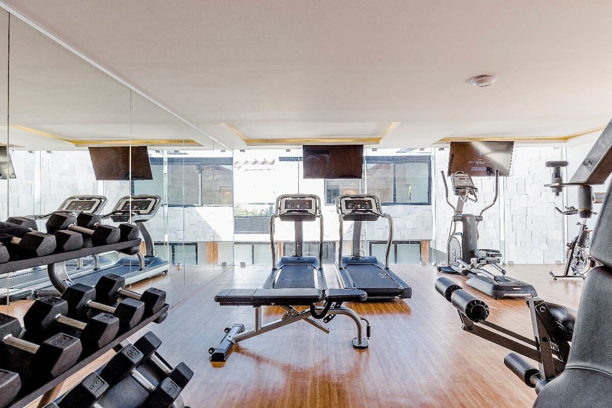 A modern gym with treadmills, dumbbells, and exercise equipment.