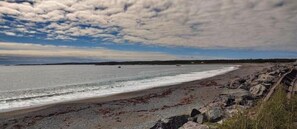 A beach with a rocky shoreline and a clear sky. - Peace in Beautiful Seaside Paradise (Gabarus)