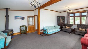 A cozy living room with a sofa, armchairs, a small table, and a fireplace.