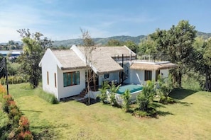 A modern house with a thatched roof, a swimming pool, and a staircase leading to a second level. - Plenary Khao Kho (Khao Kho)