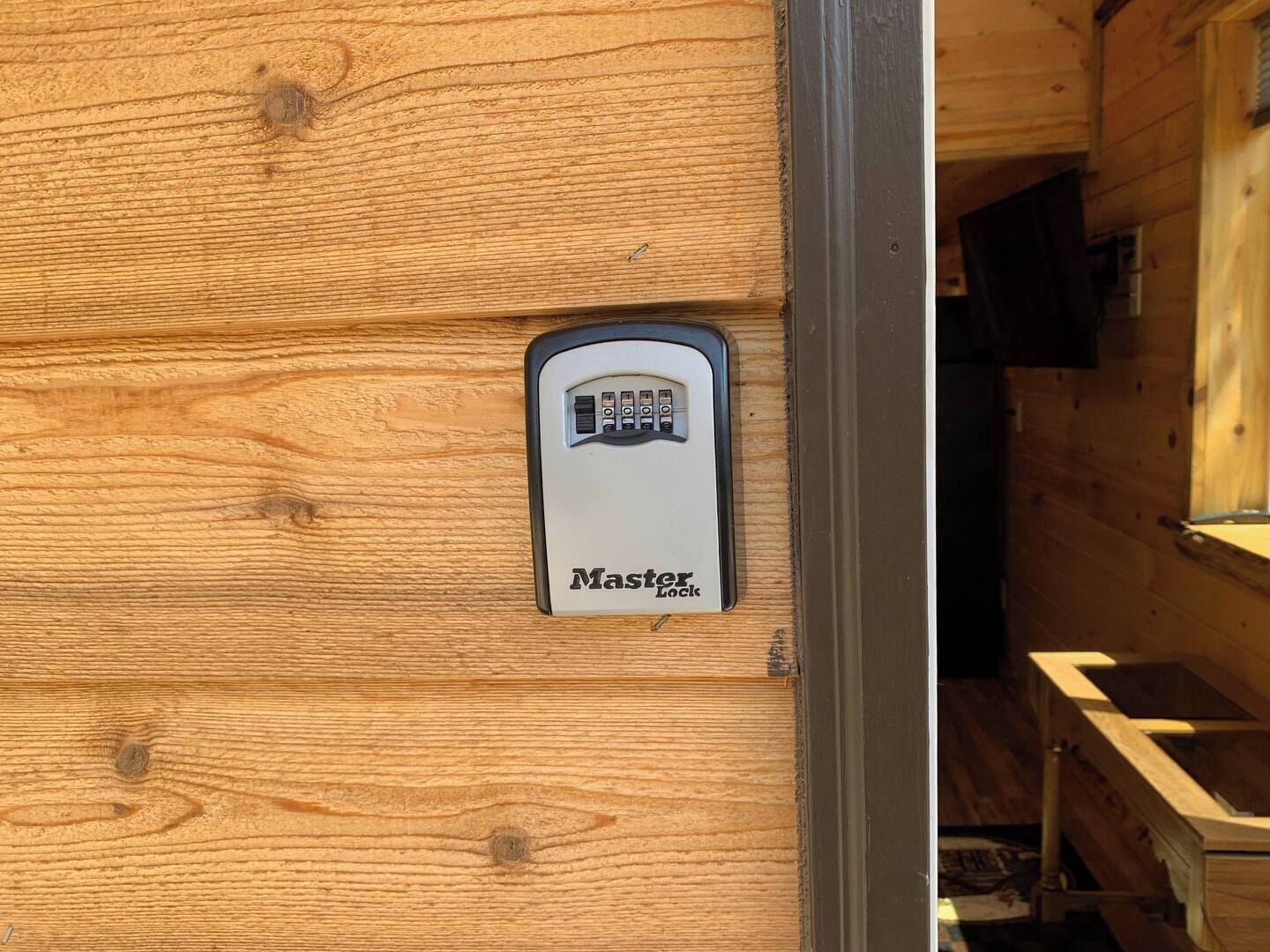 A wooden door with a security lock device labeled 'Master Lock' installed.