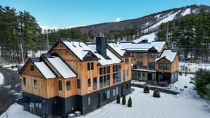 A large wooden cabin with multiple rooms, surrounded by snow-covered ground and trees. - Luxury Mountain Escape (North Conway)