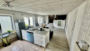 Una cocina moderna equipada con lavavajillas, refrigerador y horno empotrado. Hay ventanas que ofrecen luz natural y vistas al exterior.