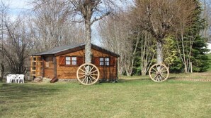 A wooden cabin with a sloped roof, large wheels, and a ladder leading to the entrance. - ZEcamping 3* familial dog friendly dans un cadre calme et relaxant (Argences-en-Aubrac)