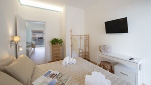Une chambre d’hôtel avec un lit, un bureau, une télévision et une vue sur l’extérieur.