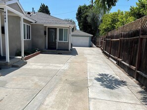 A residential property with a garage, a wooden fence, and a clear driveway. - Oasis 2BR Culver City: 6 Miles to SoFi Stadium (Culver City)