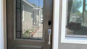 A brown front door with a glass panel and a keypad lock. - Cheerful house with EV, Parking & backyard (Culver City)