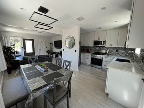 A modern kitchen with white cabinets, a built-in microwave, and a stainless steel refrigerator. - Oasis 2BR Culver City: 6 Miles to SoFi Stadium (Culver City)
