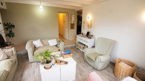 Una sala de estar con sofá, sillón, mesa de centro y una mesa de comedor.