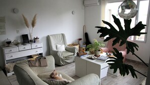Una sala de estar con un sofá, una silla, una mesa de centro y una planta grande.