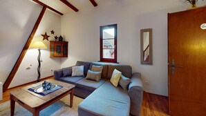 A living room with a sofa, a wooden coffee table, a lamp, and a window. - Zum Bären Duplex - 1 Parking (Colmar)