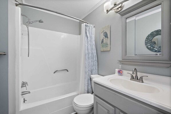 A bathroom with a bathtub, toilet, and sink.