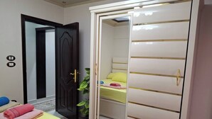 A bedroom with a bed, a wardrobe, and a door.