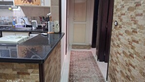 A kitchen with a granite countertop, coffee machine, and various kitchen utensils.