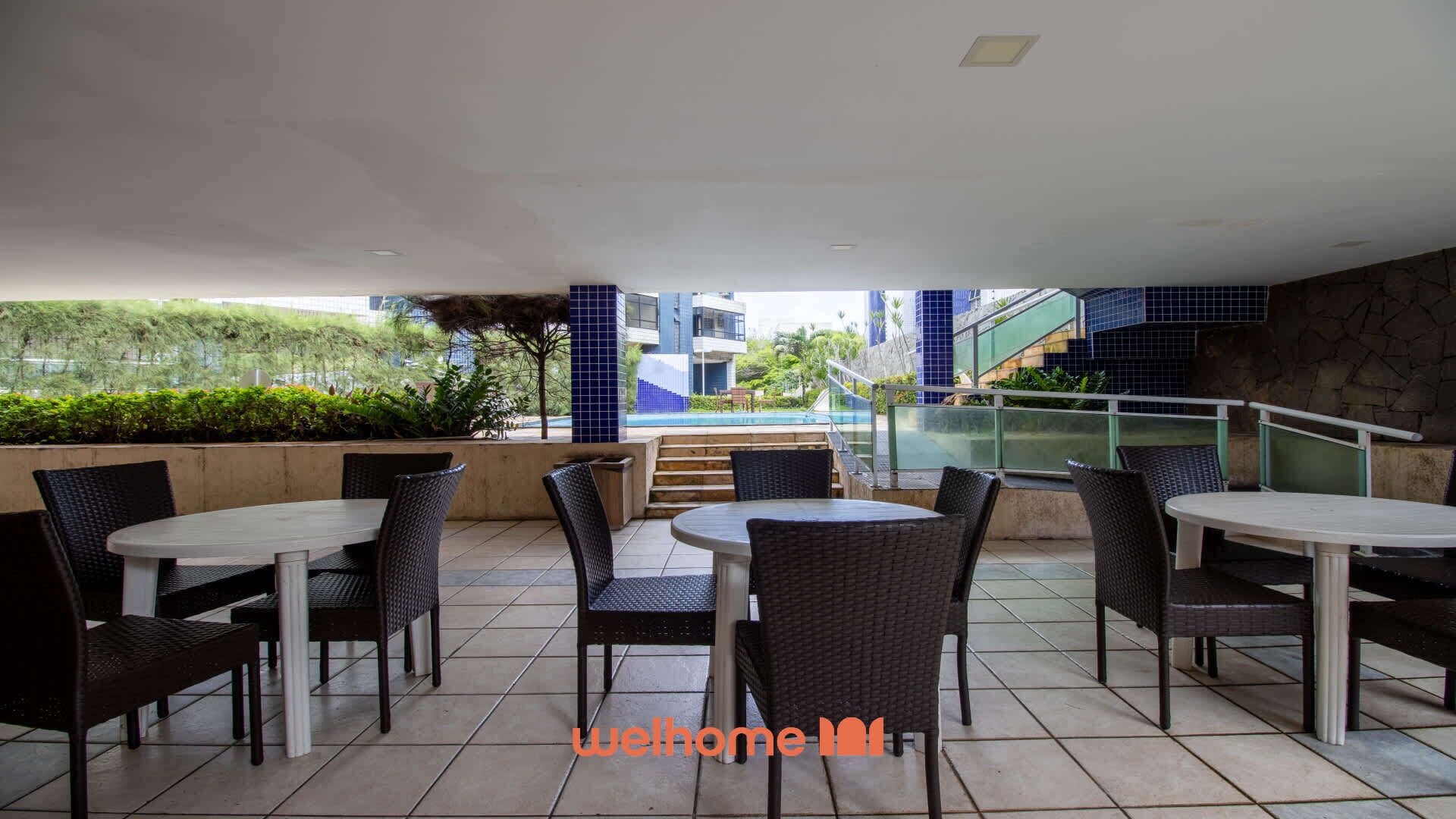 A rooftop terrace with outdoor seating and a view of a swimming pool.