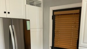 A kitchen with white cabinets, a stainless steel refrigerator, and a wooden floor. - Stunning 2-bedroom Home w/ WiFi, AC in Brookline Pittsburgh,PA (Pittsburgh)