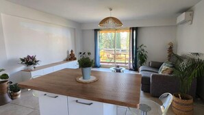 Un saló modern amb una taula de dinar de fusta, un sofà i diverses plantes.