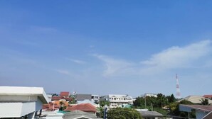 A residential area with houses, a tall communication tower, and a clear blue sky. - Ban Kai Na (Hua Hin)