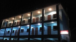 A multi-story building with balconies and a lit signboard. - Ban Kai Na (Hua Hin)