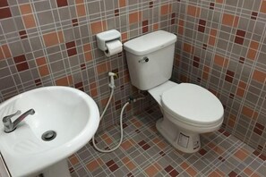 A bathroom with a toilet, sink, and tiled walls. - Ban Kai Na (Hua Hin)