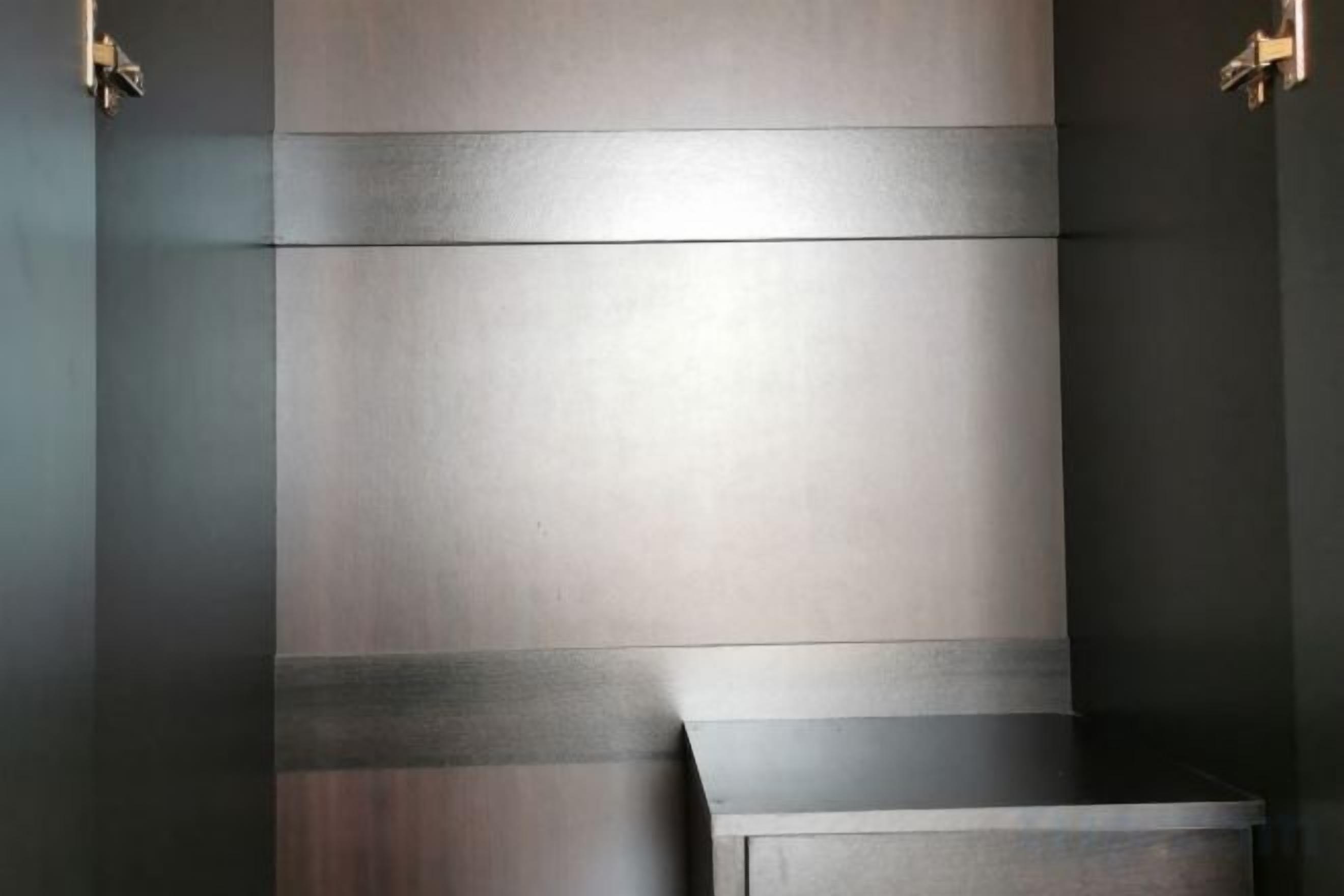 Een moderne badkamer met een minimalistisch design, met een grote spiegel en een donkere wastafel.