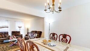 Comedor con una mesa dispuesta para cuatro personas, rodeada de sillas de madera con diseños elaborados.
