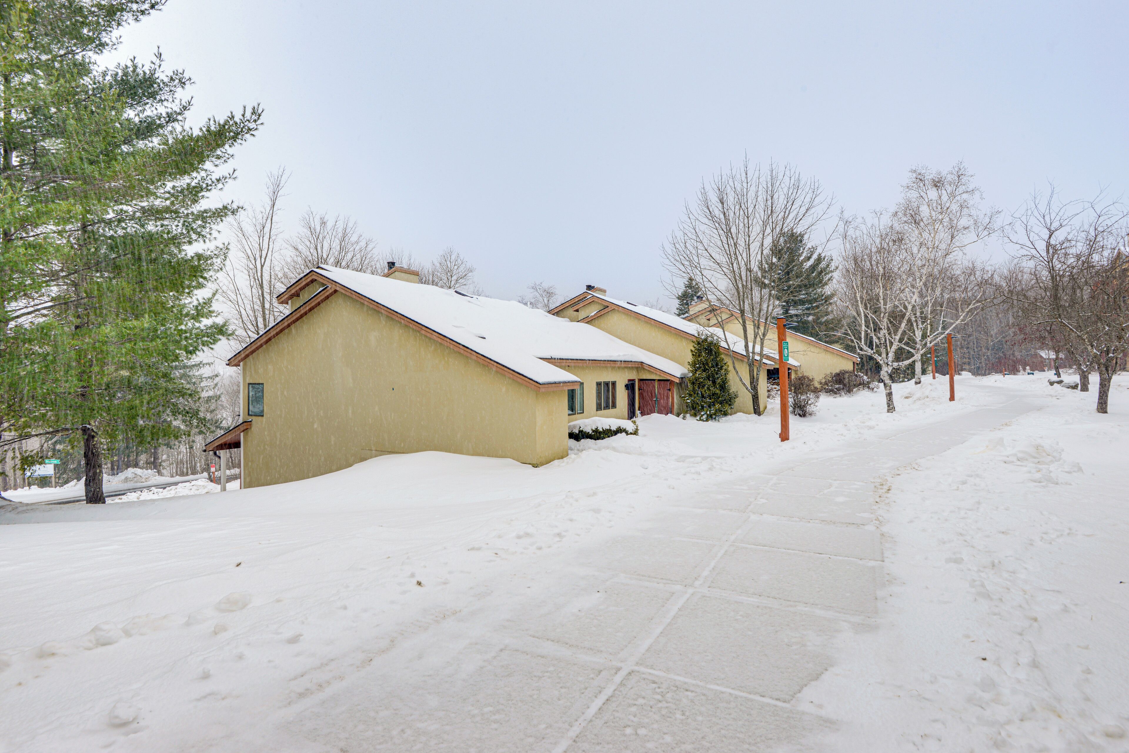 Un quartier résidentiel avec des maisons recouvertes de neige et un ciel dégagé.
