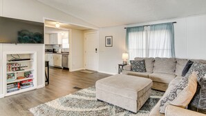 A living room with a sofa, ottoman, and a bookshelf. - Saluda River Retreat w/ Boat Ramp & Water Views! (Prosperity)
