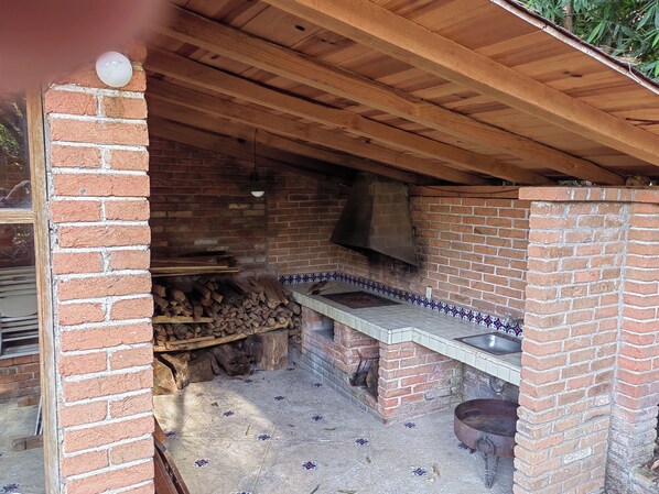 An outdoor brick oven with a tiled backsplash and a hanging pot lid. - Country houses in Avandaro, 700 m. of commercial area Avandaro (Valle de Bravo)