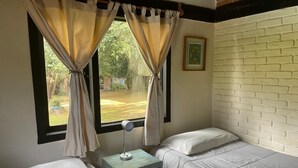A bedroom with two single beds, a nightstand with a lamp, and a window with curtains. - Country houses in Avandaro, 700 m. of commercial area Avandaro (Valle de Bravo)