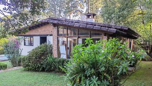 A rustic house with a sloped roof, brick walls, and large windows. - Country houses in Avandaro, 700 m. of commercial area Avandaro (Valle de Bravo)