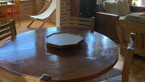 A cozy room with a round wooden table, a hammock, and a TV. - Country houses in Avandaro, 700 m. of commercial area Avandaro (Valle de Bravo)