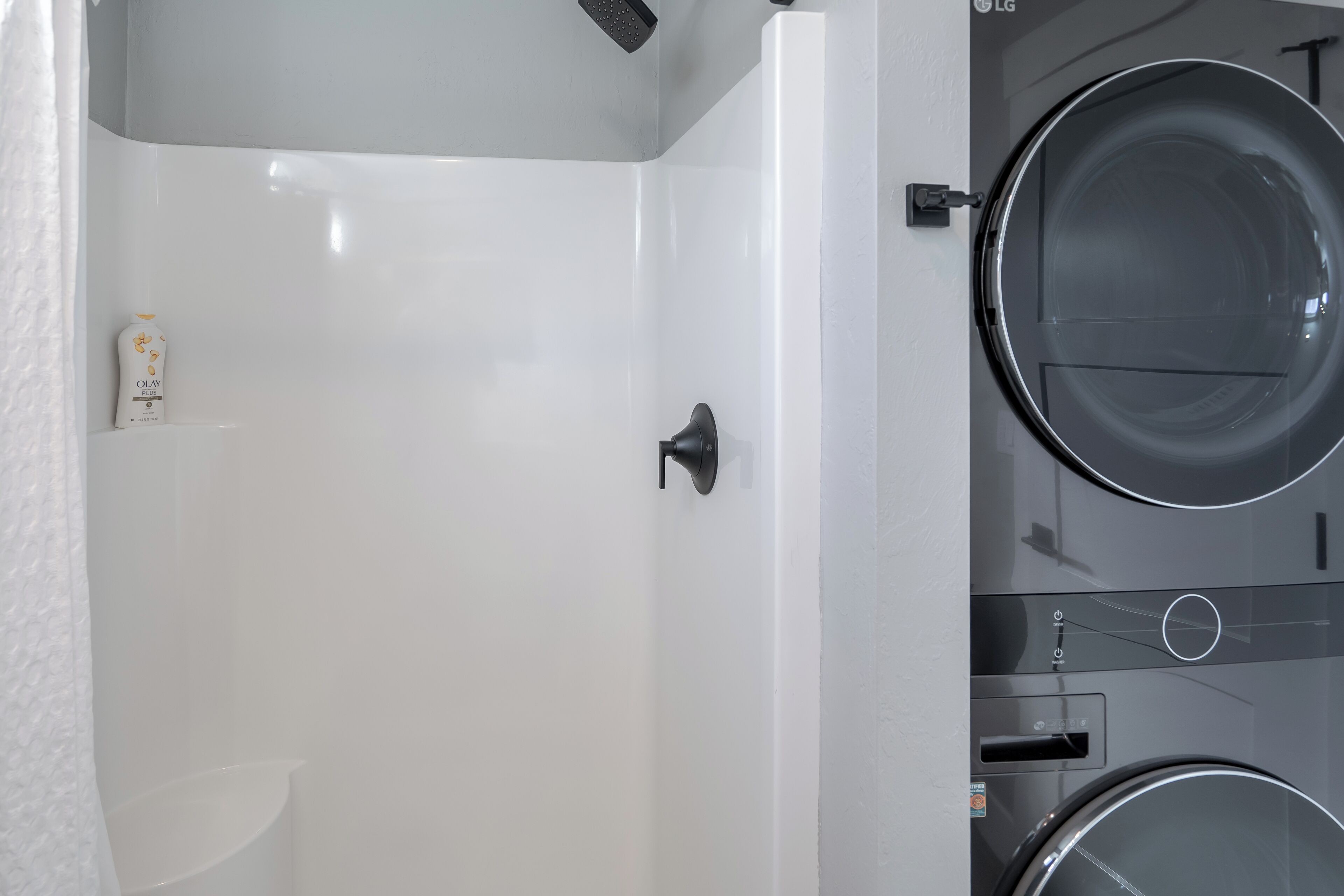 Un baño moderno con una bañera blanca, un inodoro y una lavadora.