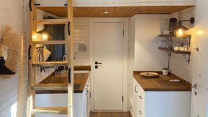 A compact, modern kitchen with wooden accents, a lofted sleeping area, and a cozy seating area. - RC Sapanca (Sapanca)