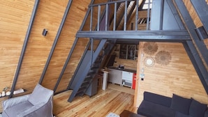 A loft-style room with a wooden floor, a sofa, a small table, and a staircase leading to an upper level. - RC Sapanca (Sapanca)