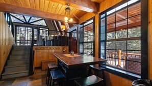 A wooden interior with a bar area, large windows, and a staircase. - Sweetin Summit Retreat (Duck Creek Village)