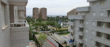 Un edificio residencial de gran altura con diseño arquitectónico moderno, que cuenta con balcones y un patio central.